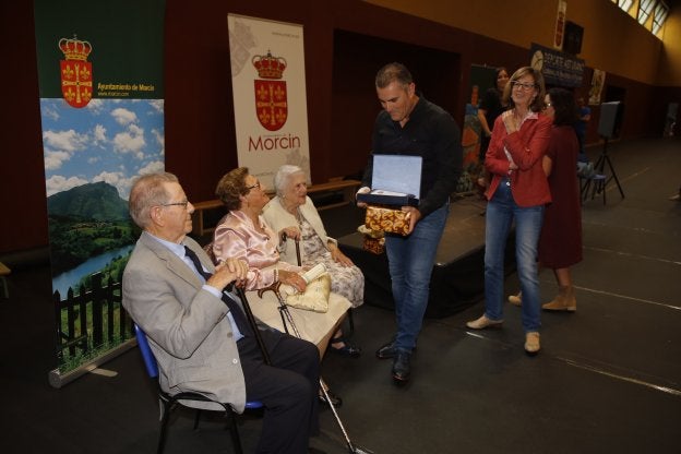 Los tres vecinos de Morcín homenajeados, en el momento de recibir los regalos.