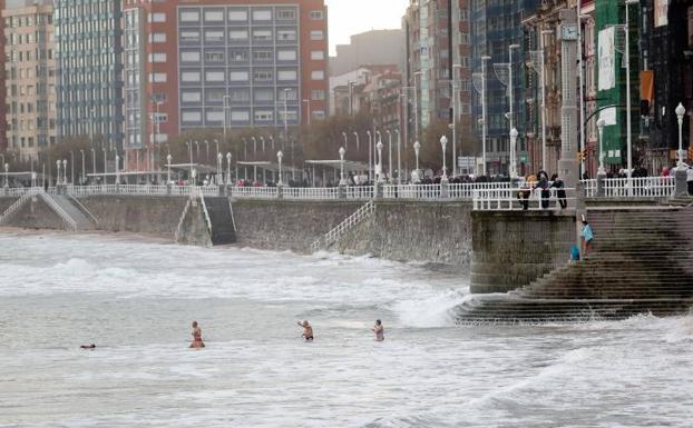 Varios bañistas, esta tarde en la playa de San Lorenzo de Gijón. /AURELIO FLÓREZ.