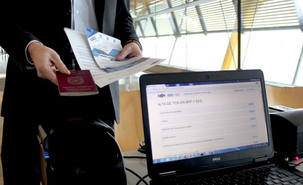 Un pasajero enseña el pasaporte en el aeropuerto de Barajas./RC