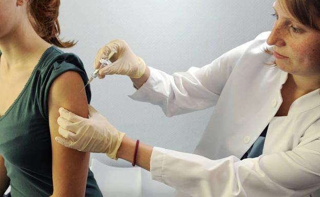 Una doctora enseña cómo llevar a cabo una vacunación contra la gripe. /THOMAS LOHNES (AFP)