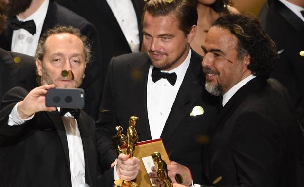 Emmanuel Lubezki, Leonardo DiCaprio y el director Alejandro Gonzalez Inarritu se sacan un selfie en la gala de los Oscar de 2016./AFP