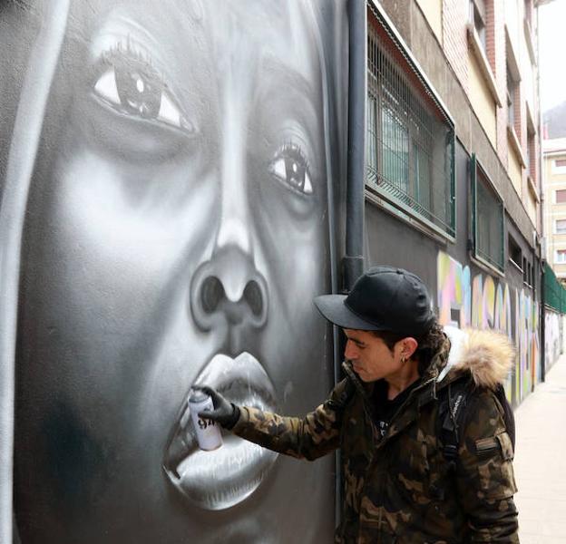 César Frey, ‘El séptimo crío’, retoca el mural dedicado a Tupac Shakur, restaurado por el Ayuntamiento de Mieres.