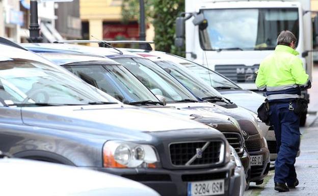 Un controlador de Eysa revisa los coches estacionados en la zona azul más próxima a la calle Independencia. /PIÑA