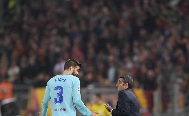 Ernesto Valverde (d) habla con Gerard Piqué en el Olímpico. /EFE