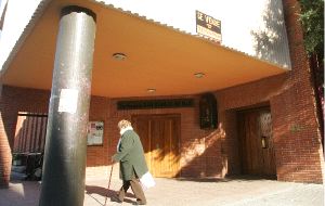 'SE VENDE'. Una mujer pasa bajo el falso cartel clavado ayer en la fachada de la iglesia. / L. SEVILLA/