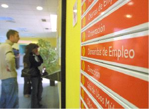 AVILÉS. Dos jóvenes examinan un cartel con ofertas de empleo en una oficina de Asturias. / MARIETA/