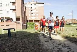 Antonio Madriñán, de blanco y con visera, corre arropado por un grupo de atletas. :: SERGIO LÓPEZ/