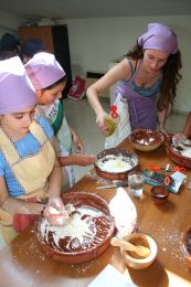 EN LA MASA. Tres niñas elaboran una receta romana. / PIÑA/