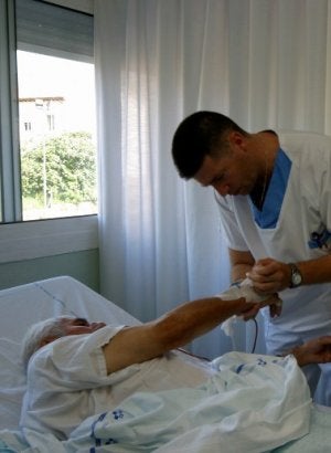 Un ATS atiende a un enfermo en el hospital de Arriondas. ::
N. ACEBAL/