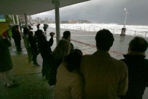 San Lorenzo. Decenas de curiosos sacaron ayer sus cámaras de fotos o de vídeo para inmortalizar la fuerza de la mar rompiendo en la zona media de la playa de San Lorenzo, ya acordonada por la Policía. ::
PAÑEDA/