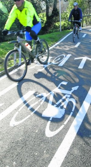 Dos ciclistas circulan por el paseo de la ría. ::
MARIETA/