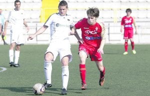 Fassani, uno de los jugadores del equipo de División de Honor juvenil del Sporting que ayer jugó con el filial, presiona al asturiano del Montañeros Dudi. :: OPAT/