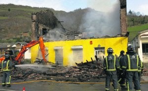 Los bomberos proceden a rebajar la altísima temperatura que aún tenían los restos de la casa aún después de apagar el fuego. :: J. M. PARDO/