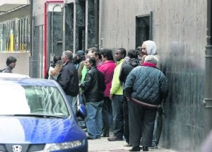 Un grupo de personas hace cola en la puerta de la Cocina Económica, el comedor de la Asociación Gijonesa de Caridad. :: E. C./