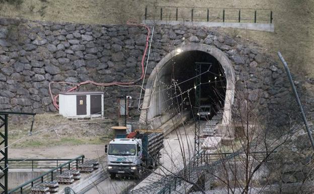 Camiones y furgonetas maniobran marcha atrás en uno de los túneles de la variante de Pajares para llevar las vías al interior. /CAROLINA SANTOS