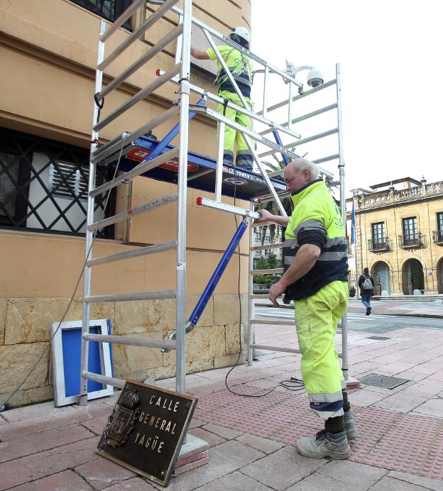 Los operarios cambiando las placas de las calles. / ALEX PIÑA