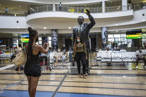 Una joven se hace una fotografía en el aeropuerto internacional OR Thambo de la ciudad sudafricana de Johannesburgo. / AFP