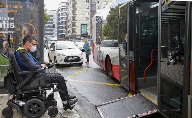 Un usuario en silla de ruedas utiliza la rampa de un autobús en Gijón./ARNALDO GARCÍA