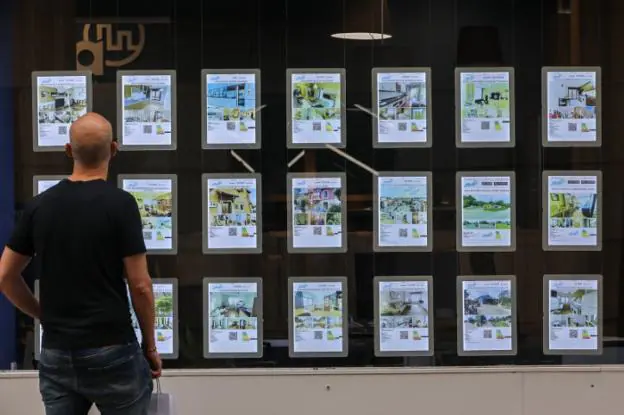 Un hombre observa los carteles de una inmobiliaria en Avilés. 